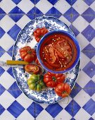 Tomato and pepper soup on a platter with tomatoes