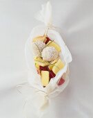 Mango with raspberries and coconut balls in baking parchment