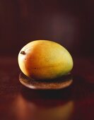 A mango on a wooden plate