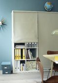 Home office: files on shelves hidden behind roller blinds