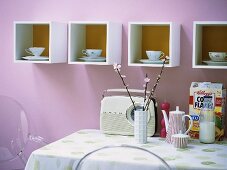 Old cups and saucers on modern shelves in kitchen