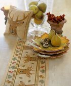 Pears, quails' eggs and autumnal decorations on table