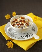 Quark with dried fruit in a cup and saucer, floral decoration
