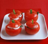 Vier gefüllte Tomaten mit Mozzarella und Basilikum