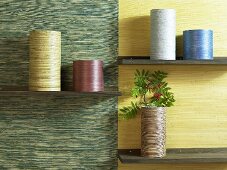 Cylindrical containers on shelves in front of different colored wall paper