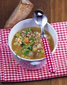 Hearty barley soup with vegetables and smoked bacon