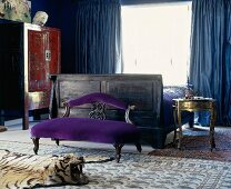 Exquisite furniture in bedroom with heavy blue curtains, silk rugs and tiger-skin rug with head