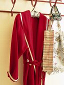 Roter Bademantel und Tasche mit Blumenmuster an der Garderobe