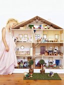 Girl leaning on dolls' house