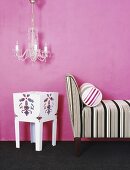 Chaise longue against pink wall