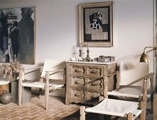 Atelierstimmung mit einfachen, aber kunstvollen Holzmöbeln und modernen Bildern an der Wand