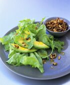 Avocado with salad leaves and toasted pumpkin seeds
