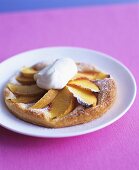 Small peach tart with cream on plate