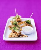 Small chicken tikka patties on cocktail sticks with mint sauce