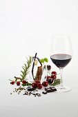 Rotweinglas und verschiedene aromatische Zutaten