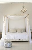 Ein antikes Himmelbett im Shabby Look mit weissen Stoffen