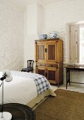 Antiker Küchenschrank im Schlafzimmer mit weisser Steinwand