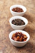 Dried chilli peppers and pepper corns in bowls