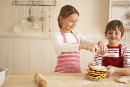Two children baking waffles for advent