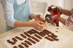 Children making chocolate Spritzgebäck (squirted biscuits)