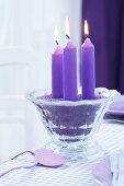 Purple candles in purple sand