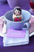 A place setting with a Russian doll in the cup