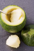 A round courgette being hollowed out