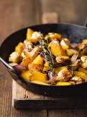 Pumpkin with chestnuts and onions in frying pan