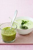Cold herb soup in glass and pea soup with mint pesto