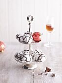 Snow caps (chocolate cookies with icing sugar) on a stand for Christmas and a glass of liqueur