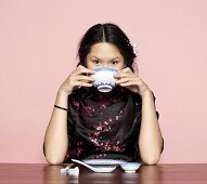 Asian woman, eating from bowl
