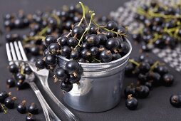 Blackcurrants in and beside a small tin