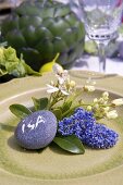 Floral decoration and pebble place card on plate