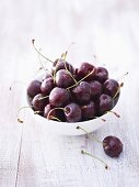 Sweet cherries in bowl, one beside it