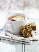 Flapjacks (Müsliriegel) und Tasse Tee auf Zeitung