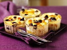 Vanilla custard with apples and raisins in glass ramekins