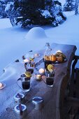 Mulled wine on snowy wooden table in garden