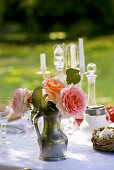 Rosenstrauss am gedeckten Tisch im Garten