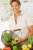 Woman holding wire basket of organic vegetables