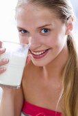 Young woman drinking a glass of milk