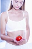 Junge Frau hält eine Tomate