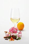 Glas Weißwein und verschiedene aromatische Zutaten