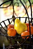 Clementines and quince in wire basket