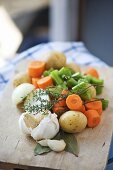 Vegetables for stew, thyme and bay leaf on chopping board