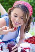 Junge Frau isst Marmelade mit ihrem Finger