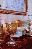 Antike Gläser und Tellerstapel auf Wandtisch