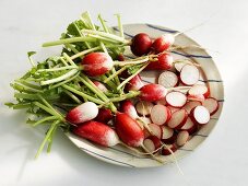 Plate of whole and sliced radishes