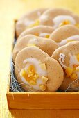 Almond macaroons with icing and orange peel in wooden box