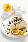 A piece of orange cream cake with nuts