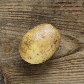 Eine Kartoffel auf Holzuntergrund